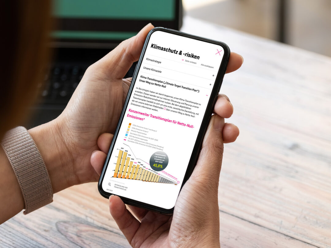 Eine Person bedient ein Smartphone mit geöffnetem Nachhaltigkeitsbericht